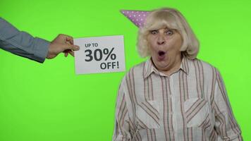 Inscription Up To 30 Percent Off appears next to grandmother. Woman celebrating with shopping bags video