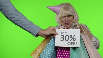 Advertisement Up To 30 Percent Off appears next to grandmother. Woman dancing with shopping bags video