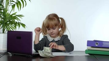 Child girl boss counting dollar cash bills. Baby businesswoman kid with money is sitting at office video