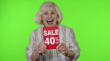 Senior grandmother showing Sale 40 percent Off banner advertisement. Online shopping. Black Friday video