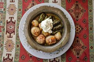 Sogan dolma Bosnian dish. Stuffed onion and wine leaf with meat. photo