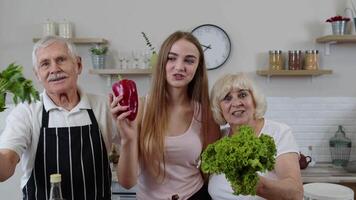 Girl with mature man and woman recommending eating raw vegetable food. Healthy nutrition diet video