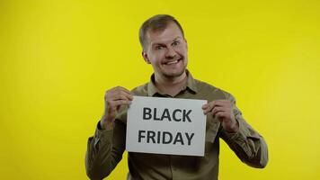 Man smiling and showing Black Friday inscription, rejoicing discounts, online shopping sales video