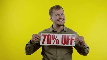 sorridente homem mostrando acima para 70 por cento fora inscrições sinais, alegria Boa descontos, baixo preços video
