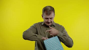 Happy man showing Up To 30 percent Off inscription from shopping bag, smiling, rejoicing discounts video