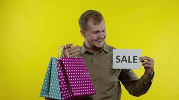 glücklich Mann zeigen Verkauf Wort Inschrift, lächelnd, suchen zufrieden mit niedrig Preise. schleppend Bewegung video