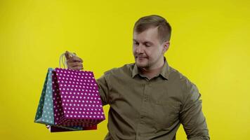 Man showing Up To 30 percent Off inscription and shopping bags, looking satisfied with low prices video