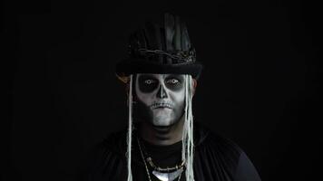 Creepy man with skeleton makeup in top-hat. Guy making faces, toothy smile. Halloween thematic party video