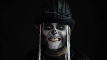 Man with skeleton makeup trying to scare, opening his mouth and showing dirty black teeth and tongue video