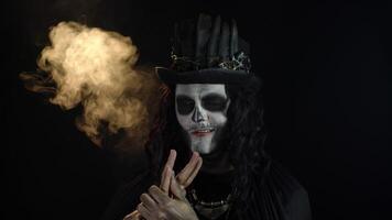 kuslig man med skelett smink i hög hatt. kille framställning ansikten, toothy leende. halloween tematiska fest video