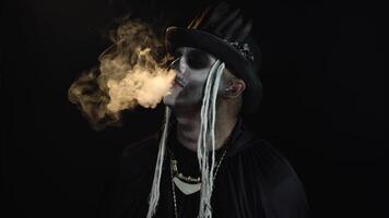 sinister Mens met professioneel schedel bedenken uitademen sigaret rook van zijn mond en neus- video