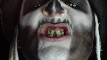 Man with skeleton makeup trying to scare, opening his mouth and showing dirty black teeth and tongue video