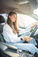 lado retrato de joven caucásico mujer conducción coche en el ciudad foto