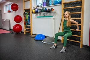 Sporty young woman doing exercise at gym. photo