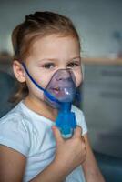 sonriente pequeño niña son sentado y participación un nebulizador máscara propensión en contra el rostro, vías respiratorias tratamiento concepto foto