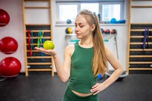 retrato de sonriente aptitud mujer participación un manzana. haciendo dieta, trabajando afuera, deporte ,saludable comiendo y estilo de vida concepto. foto