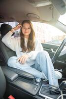 Portrait of young woman inside car interior. The car as a place in which a significant part of people lives passes photo