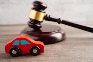 Car accident lawsuit and insurance, Judge hammer with car model. photo