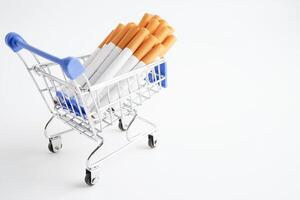 Cigarette in shopping cart, cost, trading, marketing and production, No smoking concept. photo