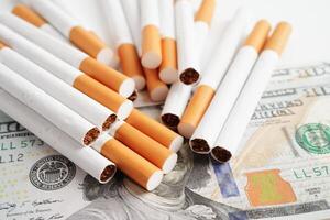 Cigarette on US dollar banknotes, cost, trading, marketing and production, No smoking concept. photo