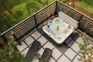 Top view of a family relaxing in an outdoor hot tub in summer photo