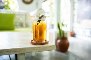 Fresh cold drink of lychee tea on a table with an elegant cafe in the background. photo