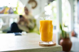 Fresh mango juice on table with luxury home blur background photo