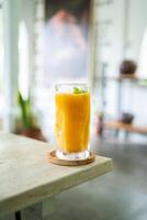 Fresh mango juice on table with luxury home blur background photo