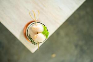 Fresh cold drink of lychee tea on a table with an elegant cafe in the background. photo