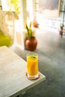 Fresh mango juice on table with luxury home blur background photo