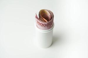 Indonesian money rupiah is in a white cup with a isolated white background photo