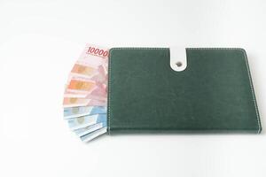 money on a book on a white background. rupiah Indonesian money. budgeting concept. copy space photo