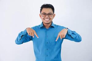 hermoso asiático masculino empleado con lentes sonriente en dedo señalando abajo actitud vistiendo azul camisa aislado en blanco antecedentes foto