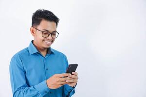 handsome smiling or happy Asian young employee man with glasses holding smart phone chatting on white isolated background. photo