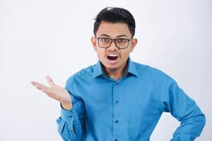 confuso o asombrado hermoso joven asiático hombre con lentes en vistiendo camisa encogiéndose de hombros manos oblicuo y mirando decepcionado aislado en blanco antecedentes foto