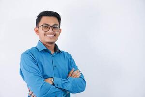 smile or happy asian businessman with glasses crossed arms and looking camera wearing blue shirt isolated on white background photo