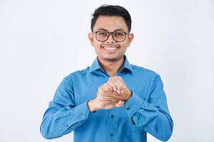 sonriente asiático empresario con lentes participación ambos manos y mirando cámara vistiendo azul camisa aislado en blanco antecedentes foto