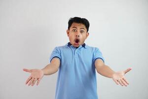 shock asian man with open hands and mouth wearing blue t shirt isolated on white background photo