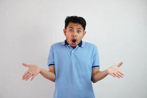 shock asian man with open hands and mouth wearing blue t shirt isolated on white background photo