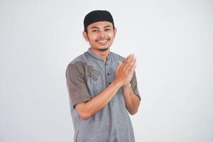 joven asiático musulmán hombre vistiendo koko ropa sonriente a dar saludo durante Ramadán y eid Alabama fitr celebracion aislado en blanco antecedentes foto
