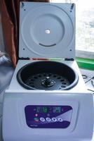 Laboratory equipment. Open laboratory centrifuge. White medical centrifuge with digital panel. Device for laboratory research. Modern lab technologies photo