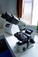 Close-up shot of microscope with metal lens at laboratory. research chemistry equipment scope biotechnology photo