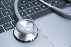 grey Stethoscope on laptop or on the keyboard of pc, close-up. macro view of a grey stethoscope on a business office laptop keyboard with selective focusing effect photo