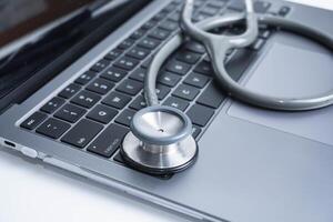 grey Stethoscope on laptop or on the keyboard of pc, close-up. macro view of a grey stethoscope on a business office laptop keyboard with selective focusing effect photo