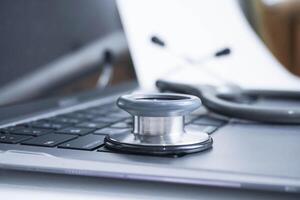 grey Stethoscope on laptop or on the keyboard of pc, close-up. macro view of a grey stethoscope on a business office laptop keyboard with selective focusing effect photo