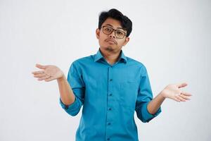 hermoso joven asiático empresario vistiendo azul camisa espectáculo manos arriba confuso yo no lo hagas saber aislado en blanco antecedentes foto