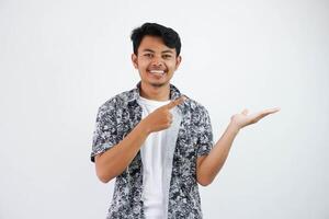 smiling asian man with an open hand with fingers pointing to the side wearing black shirt isolated on white background photo