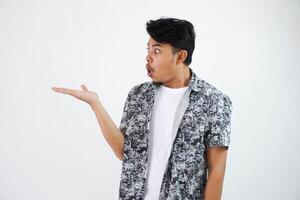 shocked asian man with fingers pointing to the side wearing black shirt isolated on white background photo