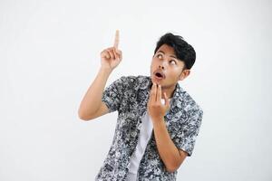 shocked Asian man holding chin gesture point finger up and looking up wearing black shirt isolated on white background photo