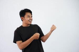 joven asiático hombre sonrisa gesto Halar cuerda pesado vistiendo negro t camisa aislado en blanco antecedentes. Copiar espacio foto